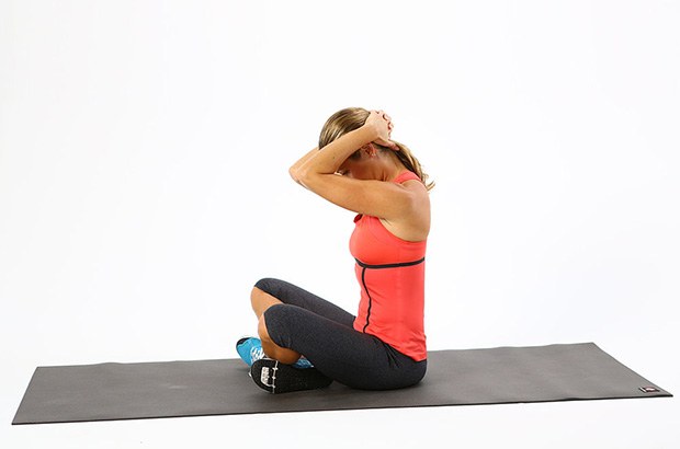 Photo of a woman completing the seated clasping neck stretch